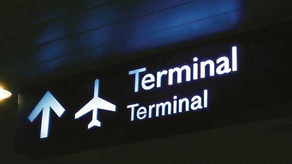 Terminal sign with white plane and arrow pointing up
