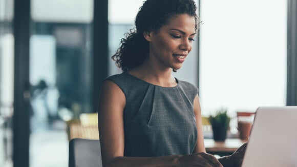 woman-smiling-looking-at-salary-report-on-computer woman-smiling-looking-at-salary-report-on-computer