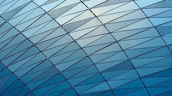 Blue glass rounded shards on building, image taken at an angle