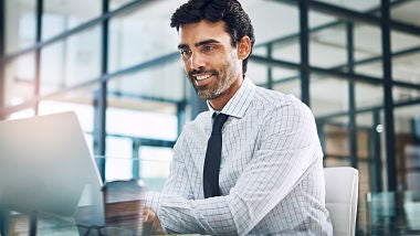man in white shirt reviewing project plan on iPad man in white shirt reviewing project plan on iPad in room with glass walls
