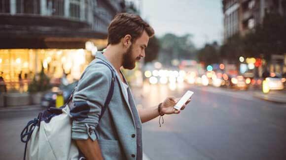 man with smartphone supply chain professional with smartphone on a busy street