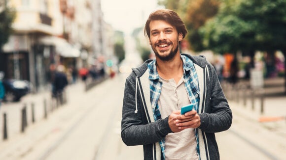man outside on mobile phone looking for ways to keep motivated during the job search