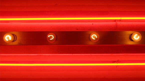 Red background with yellow strips and four bulbs lit up horizontally 