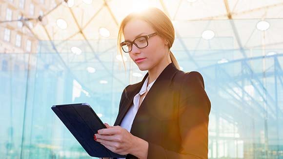 woman on ipad looking at tips to transition into industry woman on ipad looking at tips to transition into industry