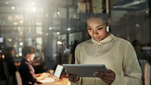 woman on a tablet woman on a tablet looking at ways to attract diverse talent