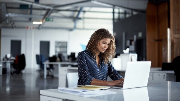 woman on laptop woman working in office on laptop looking at how to bounce back from a redundancy