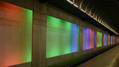 Multicoloured panel wall alongside underground tracks