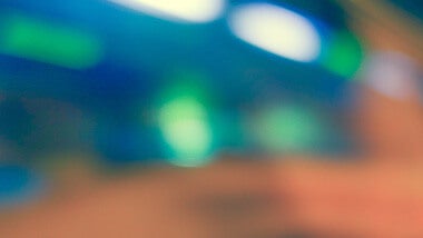 Blue blurred background with green lights and brown orange blur in left corner
