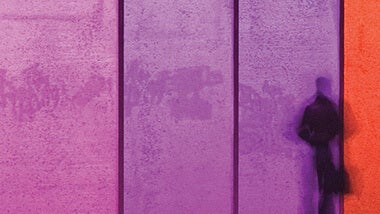 pink, purple and orange wall with shadow of a man standing aganst it