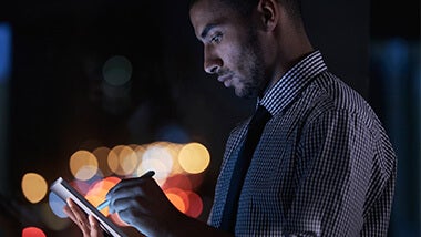 Man downloading the complete interview guide on an ipad at night