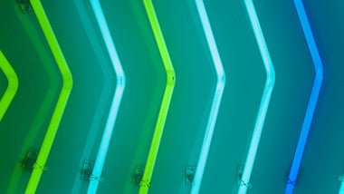 Green and blue neon arrows pointing right on blue background
