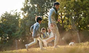 Man playing football with sons