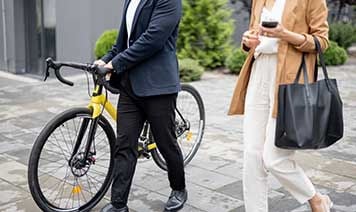 Woman walking with a man pushing a bike.
