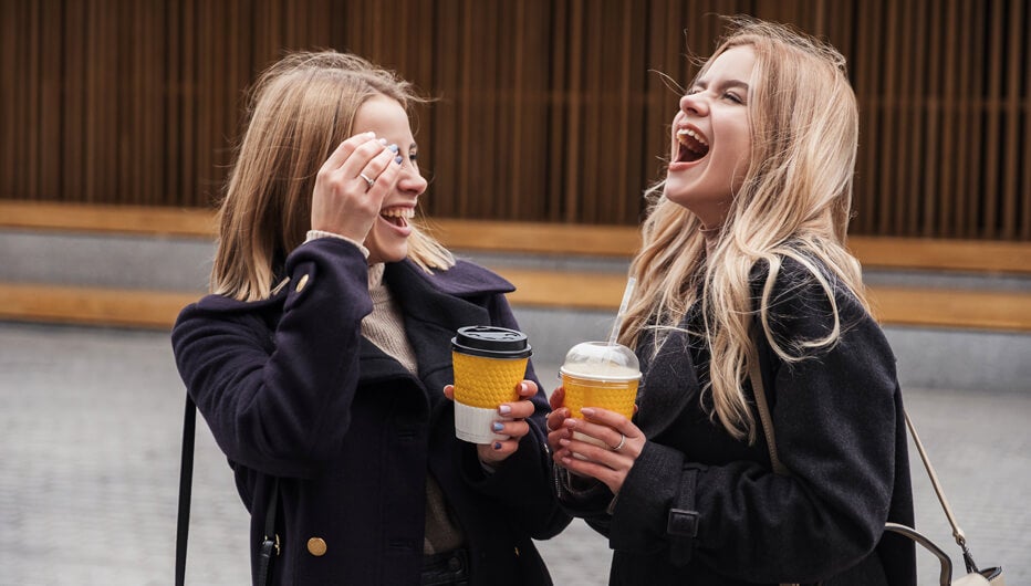 two women laughing with coffee