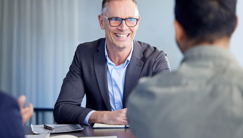 Happy mid aged business woman manager handshaking greeting clien