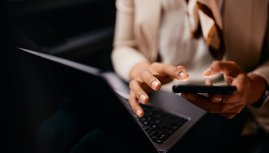 woman at laptop holding cup