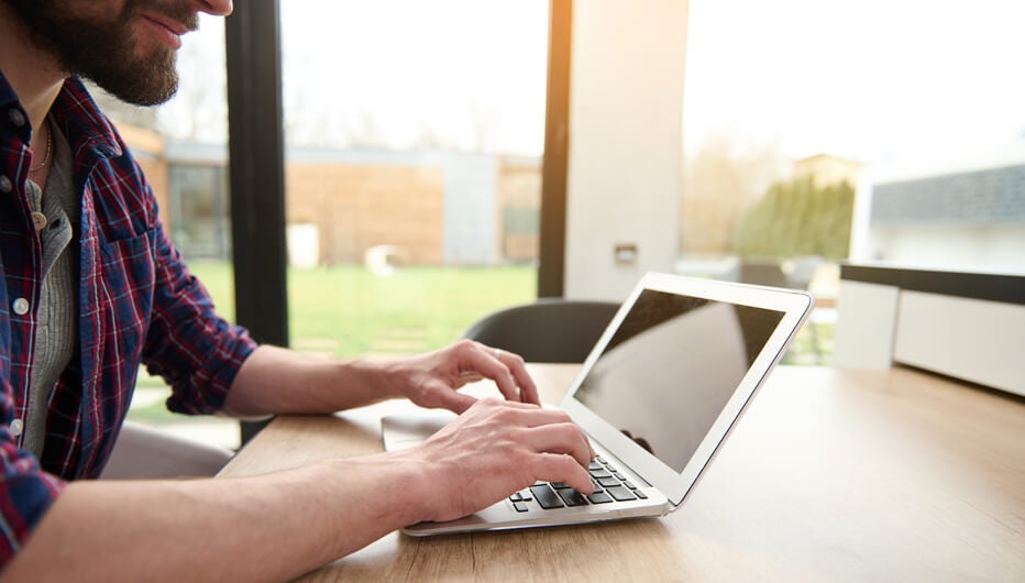 man on laptop with grass outside