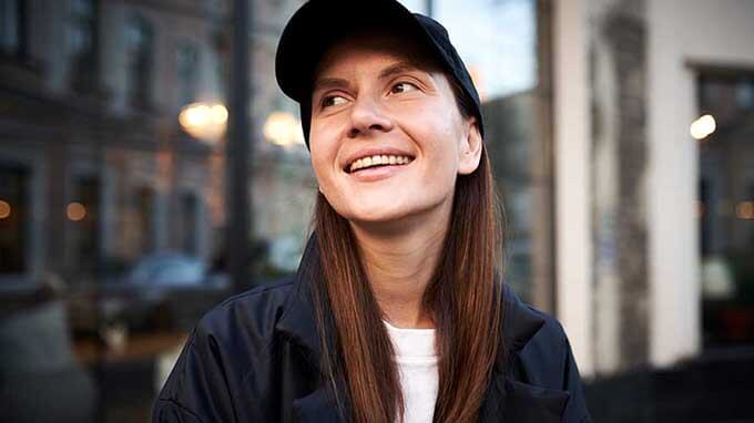 woman smiling wearing baseball cap