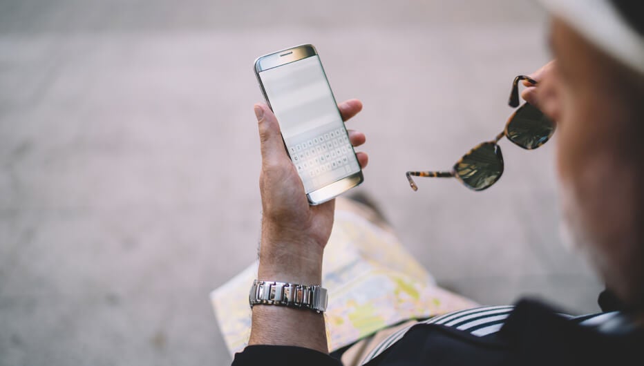 man with sunglasses looking at phone