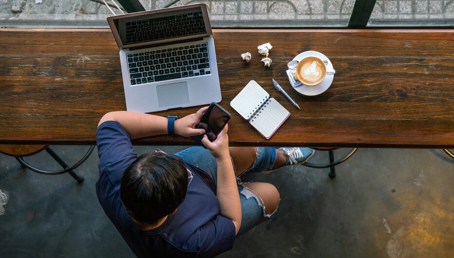 man sat at desk with coffee and phone