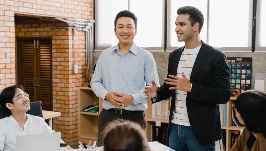 Multiracial group of young creative people in casual wear meeting brainstorming ideas about new paperwork project colleagues working together planning success strategy enjoy teamwork in small office